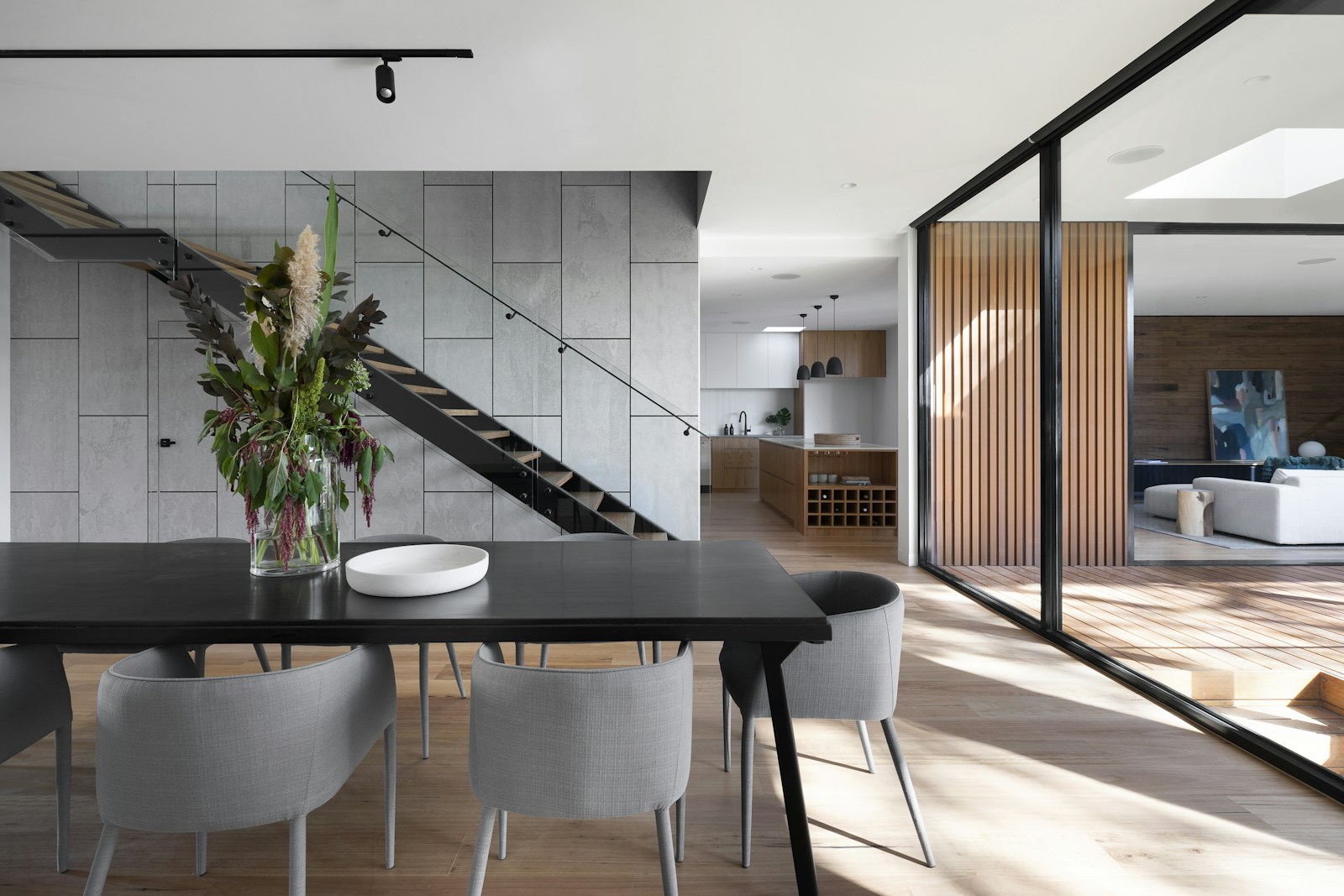 Design inspiration: an open dining area beside a wood staircase and glass doors