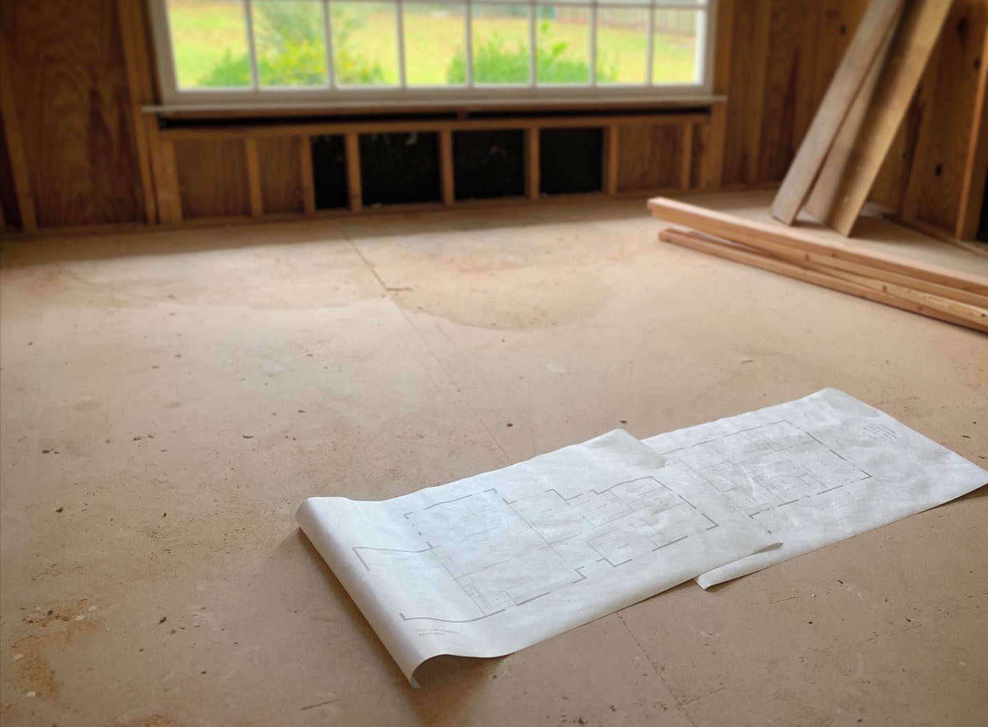 Floor plans laid out inside an unfinished room during construction