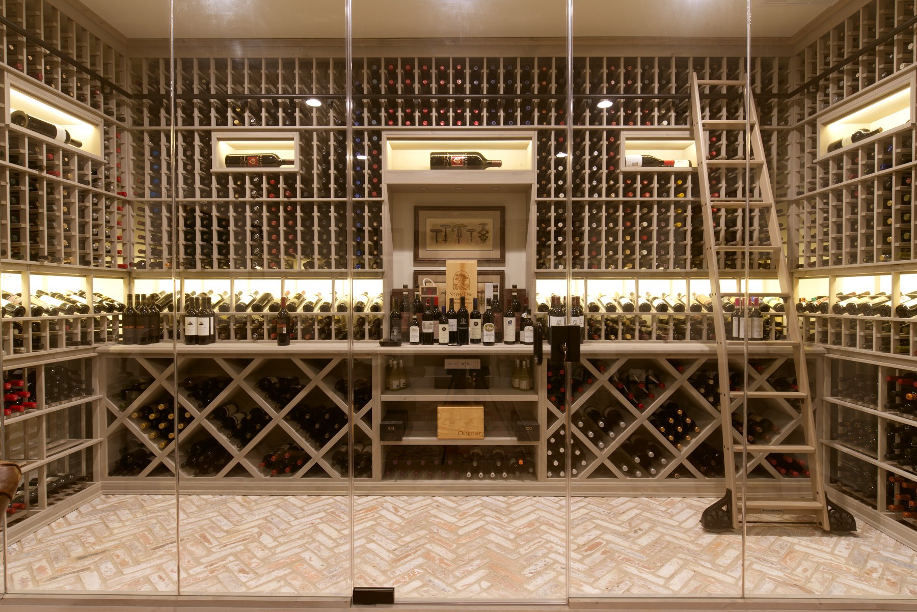 Completed custom wine room with floor-to-ceiling bottle storage, display lighting, and a rolling ladder
